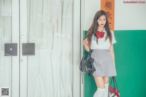 A woman in a school uniform posing for a picture.