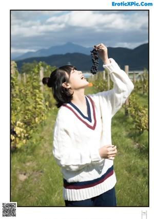 A woman in a white sweater holding a cup of coffee.