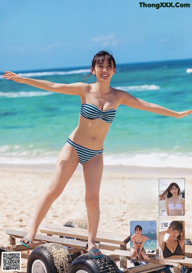 A woman in a bikini standing on a beach next to the ocean.