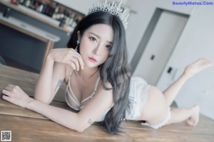 A woman wearing a white lingerie and a tia.
