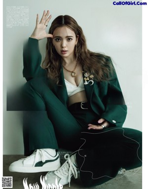A woman in a denim jacket and jeans posing for a magazine.