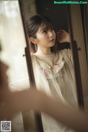 A young girl laying on a bed looking at the camera.