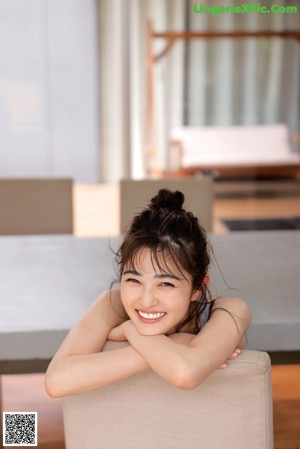 A woman in a black kimono sitting on a hammock.