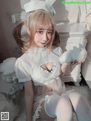 A woman in a white bunny costume posing for a picture.