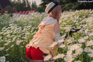 A woman in a field of daisies posing for a picture.