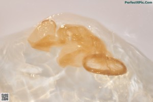 A woman sitting in a bathtub in a brown dress.