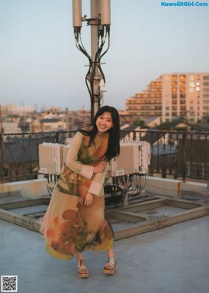 A woman sitting on a chair on top of a roof.