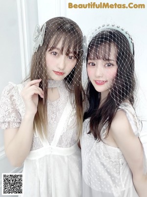 A couple of women standing next to each other on a blue background.
