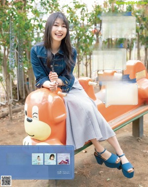 A woman sitting on a bench in a park.