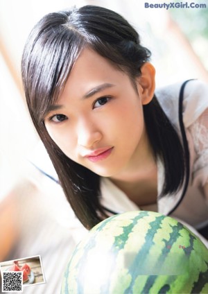 A woman holding a watermelon in her hands.