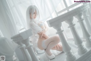 A woman in a white lingerie holding a sword.