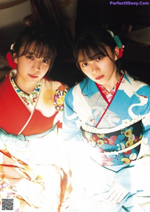Two young women sitting at a table with oranges.