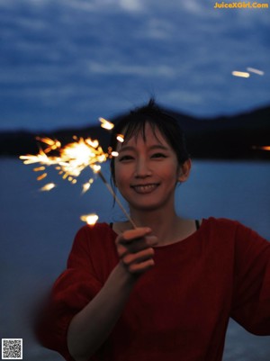 A woman standing on the edge of a body of water.