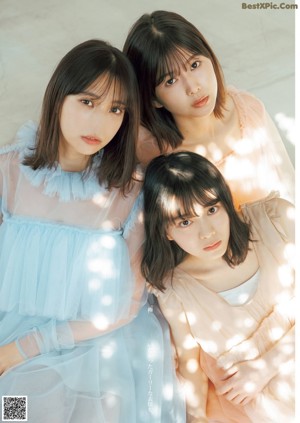 A group of three young women standing next to each other.