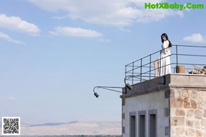 A woman sitting on top of a table next to a chair.