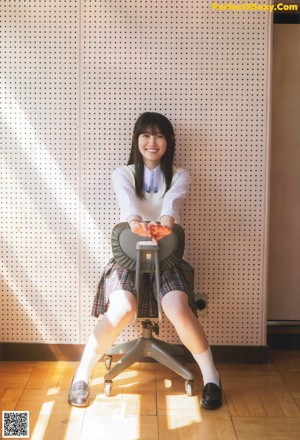 A woman in a school uniform standing in front of a staircase.