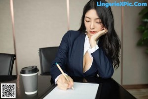 A woman sitting at a desk smoking a cigarette.