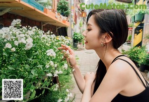 A woman standing in front of a flower shop.