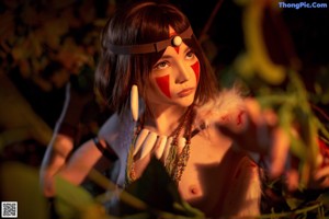 A woman dressed as an angel with red paint on her face.
